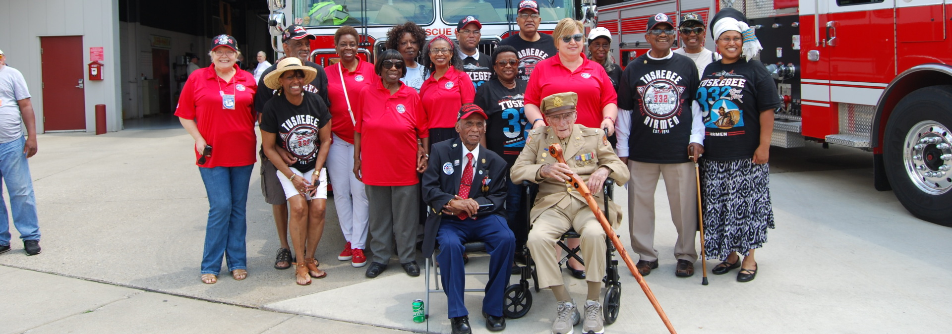 People smiling in front of firetruck